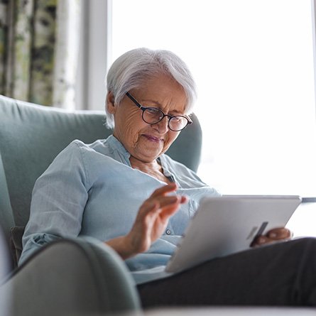 Woman looking at tablet while relaxing at home