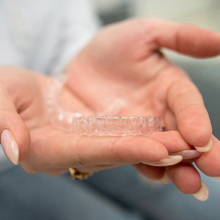 Closeup of clear aligner in patient's hands