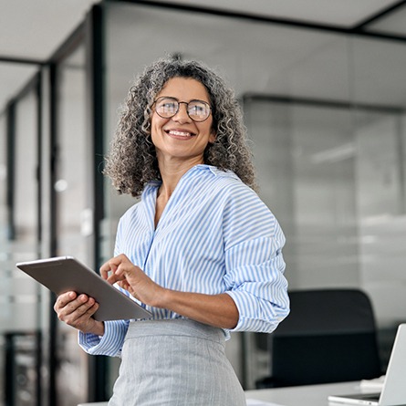 a smiling businesswoman holding a tablet