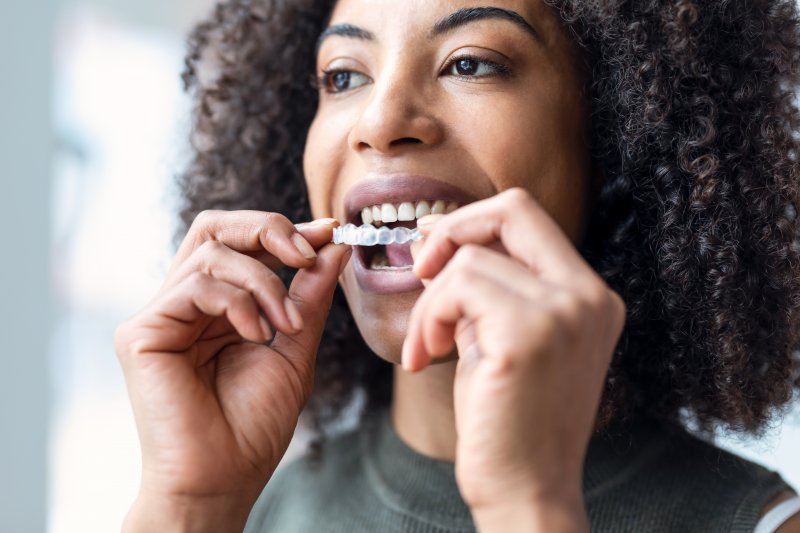 a woman preparing to wear Invisalign aligners
